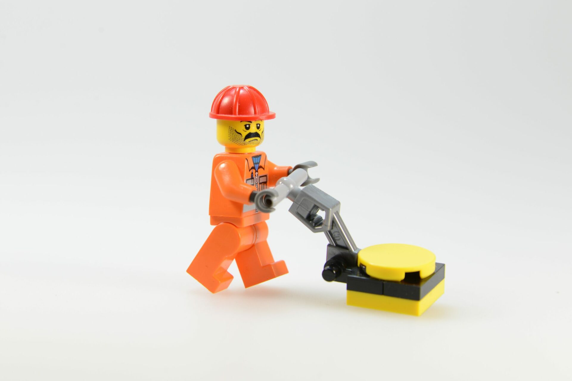 Lego Figur mit Kehrmaschine handgeführt